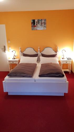 a bedroom with a white bed with two night stands at Cross-Country-Hotel Hirsch in Sinsheim
