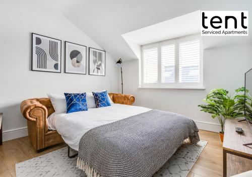 een slaapkamer met een bed, een stoel en een raam bij Chic & Central 1 Bedroom APT With Comfy king Bed & Parking by Tent Serviced Apartments Egham in Egham