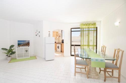 een keuken en eetkamer met een tafel en stoelen bij Esquina do Mar in Armação de Pêra