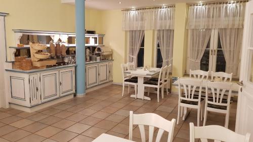 a dining room with white chairs and a table at Cross-Country-Hotel Hirsch in Sinsheim