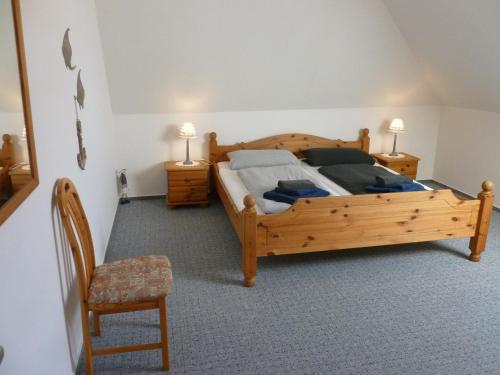 1 dormitorio con cama de madera y silla en FeWo Ostseestrand, en Neustadt in Holstein