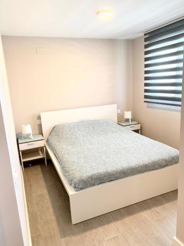 a bedroom with a white bed and two night stands at Appartement Duna beach 2 in Torrox Costa