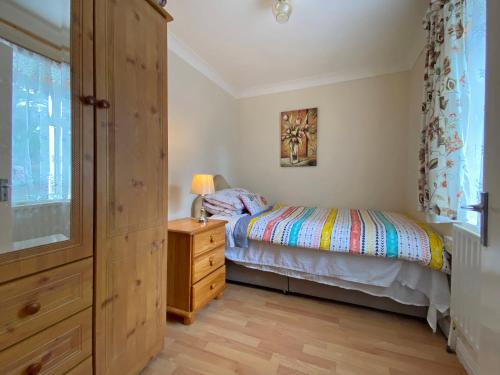ein Schlafzimmer mit einem Bett, einer Kommode und einem Fenster in der Unterkunft Cottage 397 - Carna in Carna
