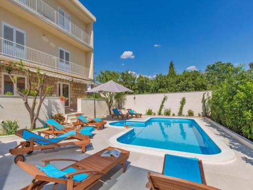 a pool with chaise lounge chairs and a swimming pool at Apartments St Thomas in Dubrovnik