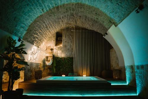 een zwembad in een kamer met een stenen muur bij Apulia Suite in Castellana Grotte