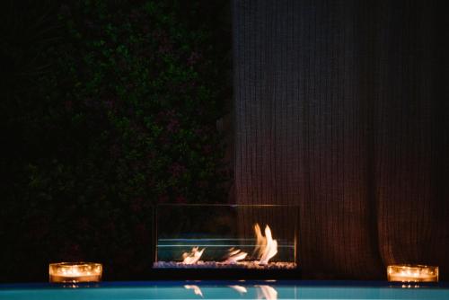 a fireplace with a fire in it next to candles at Apulia Suite in Castellana Grotte