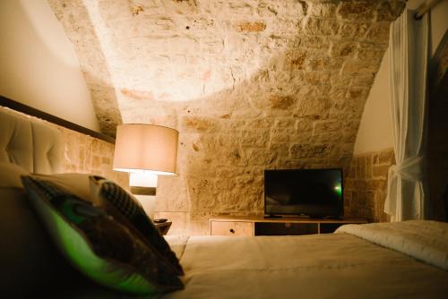 a bedroom with a bed and a tv in a room at Apulia Suite in Castellana Grotte