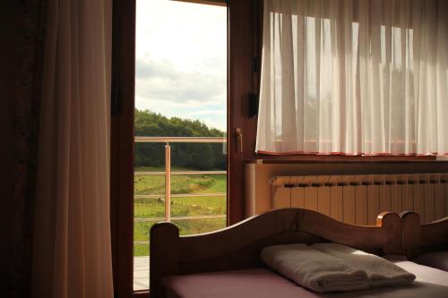 a bedroom with a bed and a window with a view at Rooms Marković in Otočac