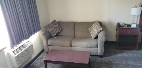 a living room with a couch and a table at Boarders Inn & Suites by Cobblestone Hotels - Broken Bow in Broken Bow