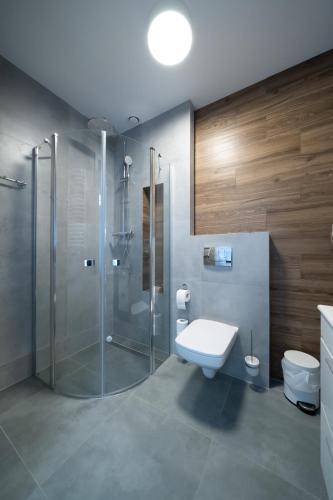 a bathroom with a glass shower and a toilet at Pensjonat Dominikański in Krasnobród