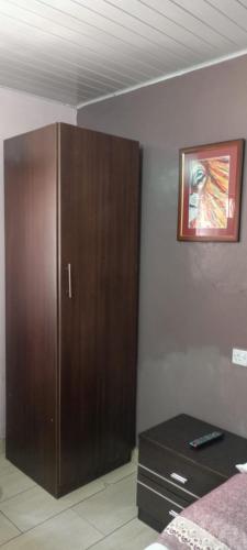 a bedroom with a brown cabinet and a table at Sunview Lodge & Restaurant in Libwezi