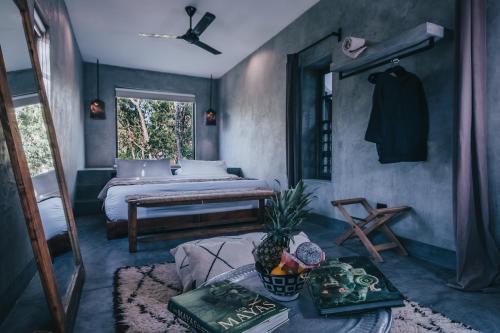 a room with a bedroom with a bed and a window at Ambre & Epices Jungle Hotel & Spa in Tulum