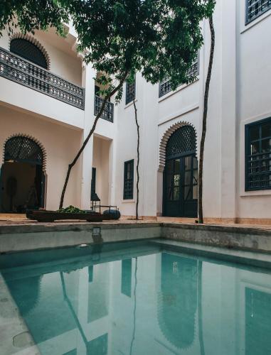 a swimming pool in front of a building at Ambre & Epices Jungle Hotel & Spa in Tulum