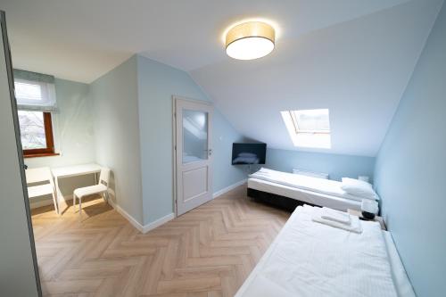 a small room with a bed and a desk at Pensjonat Dominikański in Krasnobród