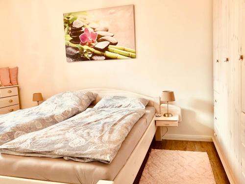 伊策霍的住宿－City Apartment 09，卧室配有一张床,墙上挂有绘画作品