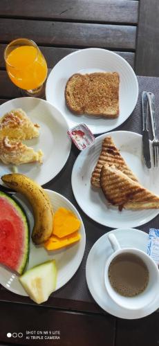 a table with plates of breakfast food on it at Pousada Recanto das Maritacas in Brotas