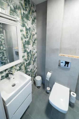 a bathroom with a white sink and a toilet at Pensjonat Dominikański in Krasnobród