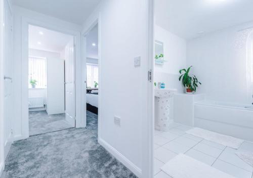 a white bathroom with a tub and a sink at LUXURY 3 BEDROOM HOUSE Close to Manchester Center in Manchester