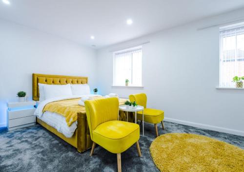 a bedroom with a bed and two chairs and a table at LUXURY 3 BEDROOM HOUSE Close to Manchester Center in Manchester