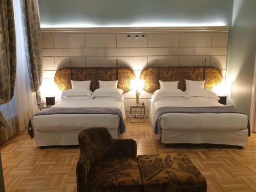 a hotel room with two beds and a chair at Hotel Number Nine in Florence