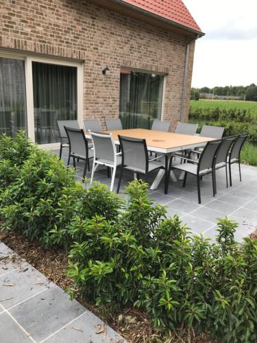 a wooden table and chairs on a patio at Oscaar vakantiewoning in bos in Koekelare