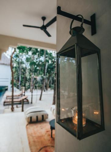 a black lantern hanging on a wall next to a patio at Ambre & Epices Jungle Hotel & Spa in Tulum