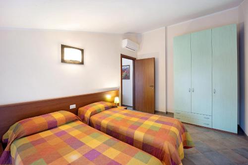 ein Hotelzimmer mit 2 Betten und einem Schrank in der Unterkunft Virginia Agriturismo La Scuderia in Molino Nuovo