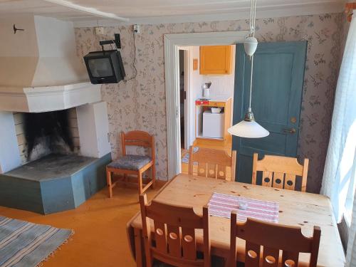 a living room with a dining table and a fireplace at Lövånger Kyrkstad in Lövånger