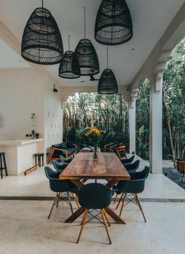 a dining room with a wooden table and chairs at Ambre & Epices Jungle Hotel & Spa in Tulum