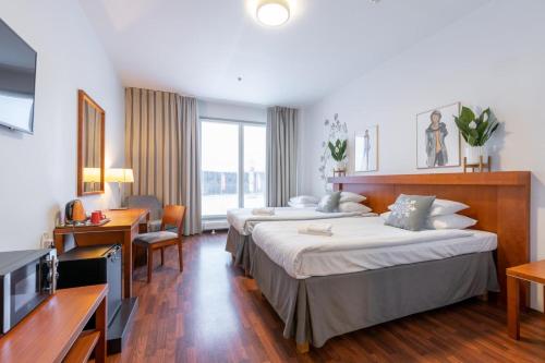 um quarto de hotel com duas camas e uma televisão em Hotel Tuulonen em Tuulos