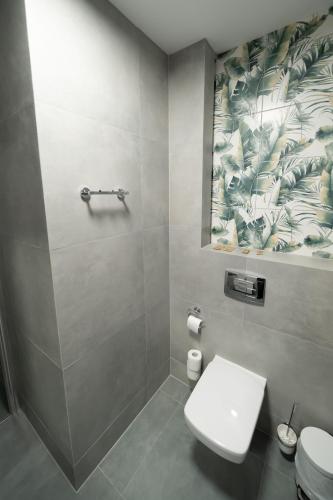 a bathroom with a white toilet and a shower at Pensjonat Dominikański in Krasnobród