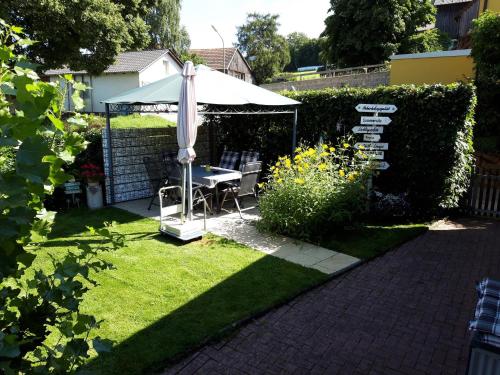 a garden with an umbrella and a table and a bench at Ferienhaus Heuberger in Tännesberg