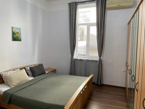 een slaapkamer met een bed en een raam bij The Central Post Apartments in Sofia