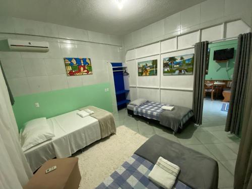 een kamer met 2 bedden en een bank. bij Kitnet Praia do Trapiche in Penha