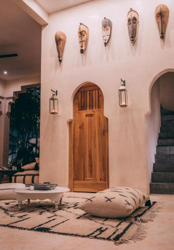 a living room with a wooden door and a rug at Ambre & Epices Jungle Hotel & Spa in Tulum