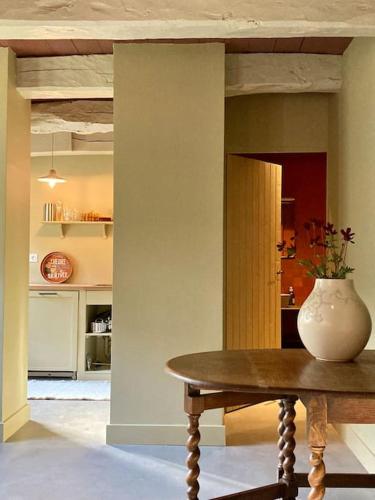 un vase assis sur une table dans une cuisine dans l'établissement Encore une fois, Entre deux, à Locmalo