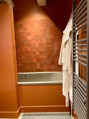 une salle de bain avec baignoire dans une chambre dans l'établissement Encore une fois, Entre deux, à Locmalo