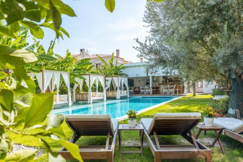 un resort con piscina, due sedie e un tavolo di Kose Konak Butik Hotel-Special ad Alaçatı