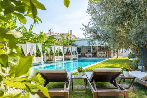 a resort with a swimming pool and two chairs and a table at Kose Konak Butik Hotel-Special in Alaçatı