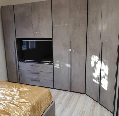 Schlafzimmer mit einem Bett, einem TV und Schränken in der Unterkunft Gilda's room in Bologna