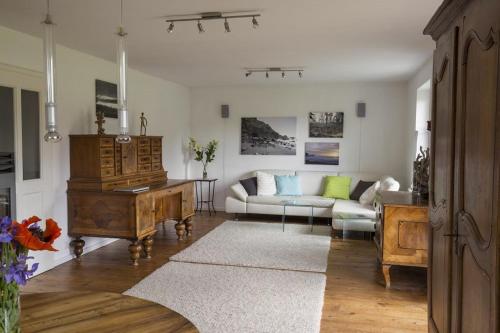 a living room with a couch and a piano at 5 Sterne FeWo mit Garten und Bergblick in Chiemsee-Nähe in Übersee