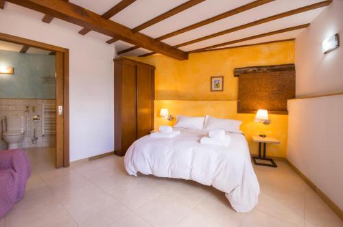 a bedroom with a large bed with towels on it at O Canto da Terra in Pantón