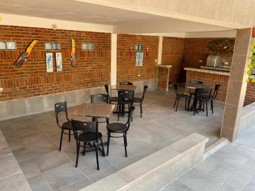 a restaurant with tables and chairs and a brick wall at Hotel brisas del pacifico ladrilleros in Ladrilleros