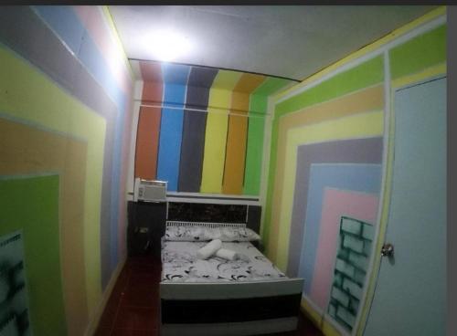 a room with a rainbow colored wall with a bed at Cabanatuan City PNY TRANSIENT INN 3 in Cabanatuan