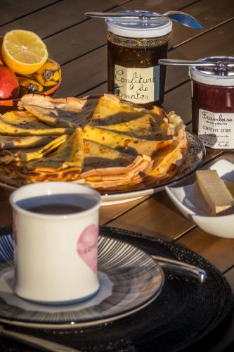 Una mesa con un plato de comida y una taza de café. en Chambres d'hôtes Enmarcade, en Touget