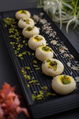 a black tray with some food on it at The Nest Luxury Resort in Jaipur