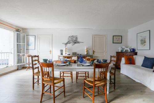 a living room with a table and chairs at Au coeur du port, vue unique, appartement pour 6 in Saint-Martin-de-Ré