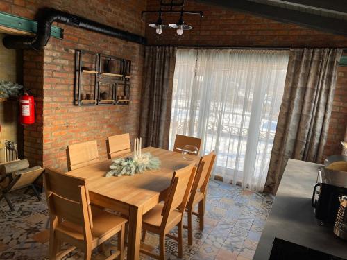 a dining room with a wooden table and chairs at BrickWood in Verkhniy Koropets