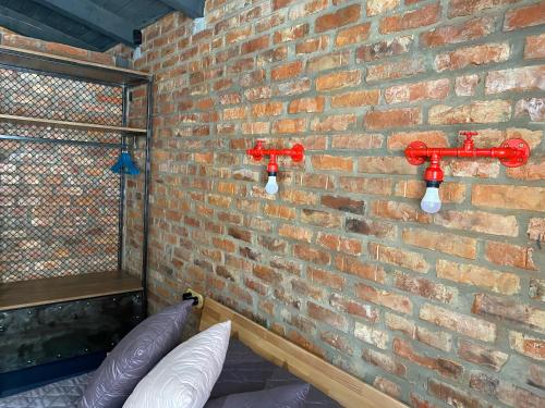 a brick wall with two red valves on it at BrickWood in Verkhniy Koropets