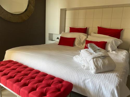 a large white bed with red pillows and a red bench at Gran Paradiso Hotel Spa in San Giovanni Rotondo